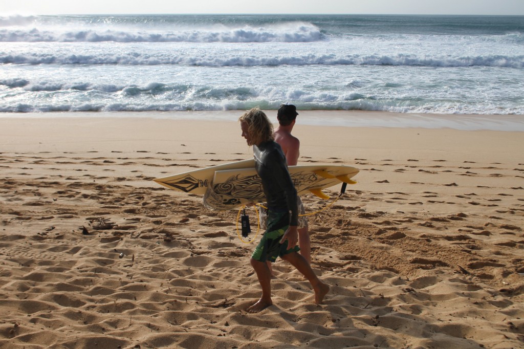 Team Volcom Pro Surfer Gavin Beschen comes in from riding Banzai Pipeline, happy but with a broken board.